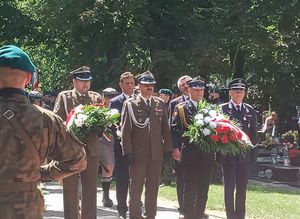 Przedstawiciele  Wojska, Straży Pożarnej i Policji stoją przed pomnikiem Lotników Polskich.