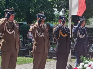 Przedstawiciele  Wojska, Straży Pożarnej i Policji oddają honory  przed pomnikiem Lotników Polskich.