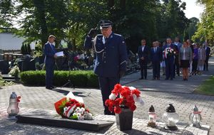 Młodszy inspektor Waldemar Popczyk oddaje honor przed pomnikiem Lotników Polskich po złożeniu wiązanki kwiatów.