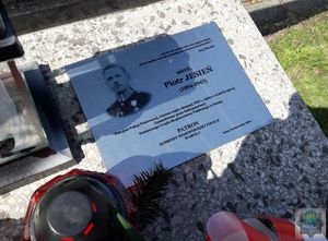 fragment płyty nagrobka z tablicą upamiętniająca sierżanta Piotra Jesienia  z jego wizerunkiem