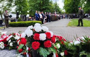 Cmentarz komunalny w Oleśnie. Na płycie Pomnika Lotników Polskich leży wiązanka biało-czerwonych kwiatów.