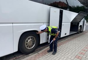 Ulica Krasickiego w Oleśnie, okolica Domu Harcerza.  Policjantów ruchu drogowego sprawdza bieżnik koła w autokarze.