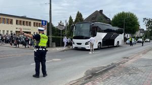 Ulica Krasickiego w Oleśnie, okolica Domu Harcerza. Policjant ruchu drogowego wstrzymuje ruch pojazdów. W tle autokar i uczestnicy wyjazdu z bagażami.