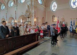 Kościół parafialny w Oleśnie. Poczet sztandarowy oleskiej Policji oddaje honor przed ołtarzem głównym.