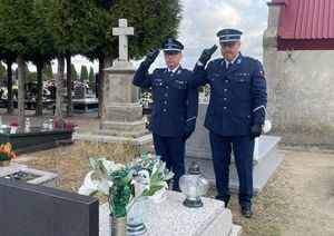 Zastępca Komendanta Powiatowego Policji w Oleśnie młodszy inspektor Waldemar Popczyk i Naczelnik Wydziału Prewencji oddają honory przy symbolicznym grobie sierżanta Piotra Jesienia patrona Komendy Wojewódzkiej Policji w Opolu na cmentarzu parafialnym w Przystajni.