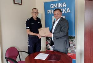 Zdjęcie w kolorze przedstawia jak Komendant Powiatowy Policji w Oleśnie odbiera karton z narkotestami od Burmistrza Miasta i Gminy Praszka.