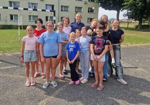 Zdjęcie w kolorze, przedstawia dziewczęta pozujące w grupie do zdjęcia wspólnie z policjantką.