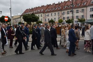 Zdjęcie w kolorze przedstawia przemarsz korowodu dożynkowego ulicami miasta.