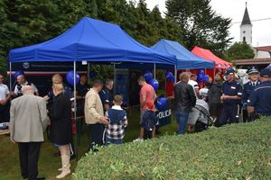 Zdjęcie w kolorze przedstawia uczestników imprezy odwiedzających policyjne stoisko promocyjne.