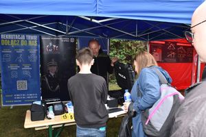 Zdjęcie w kolorze przedstawia uczestników imprezy odwiedzających stoisko policyjne.