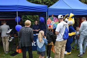 Zdjęcie w kolorze przedstawia uczestników imprezy odwiedzających stoisko policyjne.