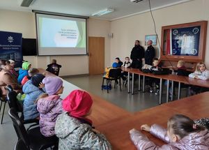 Zdjęcie w kolorze przedstawia grupę dzieci w świetlicy KPP podczas wykładu na temat bezpieczeństwa w sieci.