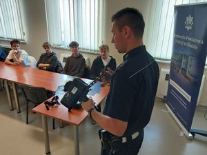 Zdjęcie w kolorze przedstawia młodzież podczas prelekcji z policjantem ruchu drogowego.