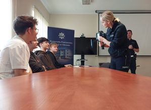 Zdjęcie w kolorze przedstawia młodzież podczas prelekcji z policjantem ruchu drogowego.