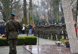 Zdjęcie w kolorze przedstawia salwę honorową w wykonaniu kompanii wojska polskiego.