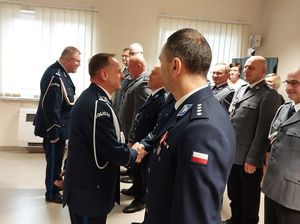 Zdjęcie w kolorze przedstawia Komendanta powiatowego Policji w Oleśnie witającego się ze zgromadzonymi policjantami i pracownikami cywilnymi.