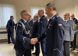 Zdjęcie w kolorze przedstawia I Zastępcę KWP w Opolu Oraz Nowego KPP w Oleśnie witającego się z policjantami i pracownikami cywilnymi.