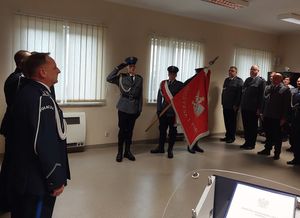 Zdjęcie w kolorze przedstawia nowego Komendanta Powiatowego Policji podczas przemówienia w tle Poczet Sztandarowy KPP w Oleśnie