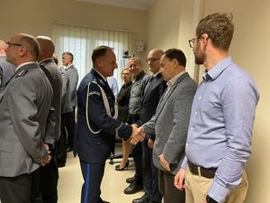 Zdjęcie w kolorze przedstawia Komendanta Powiatowego Policji w Oleśnie witającego się z pracownikami cywilnymi.