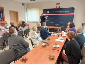 Zdjęcie w kolorze przedstawia salę wykładową w której zgromadzeni pracownicy cywilni biorą udział w wykładzie.