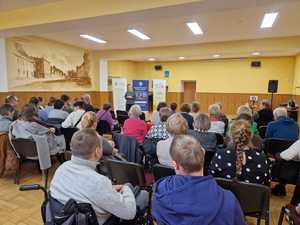 Zdjęcie w kolorze przedstawia, kilkadziesiąt osób siedzących w sali lustrzanej Miejskiego
domu kultury w Oleśnie.