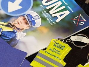 Zdjęcie w kolorze przedstawia elementy promocyjne leżące obok siebie na pulpicie.