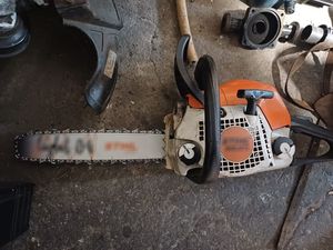 Zdjęcie w kolorze przedstawia piłę spalinową położona na betonowej posadzce.