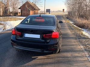 Zdjęcie w kolorze przedstawia nieoznakowany czarny pojazd policji, za tylną szybą czerwony napis policja.