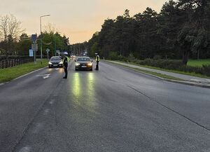 Zdjęcie w kolorze przedstawia policjantów wykonujących kontrole tzeźwości kierujących