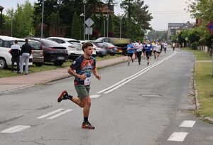 Zdjęcie w kolorze przedstawia policjanta, który biegnie