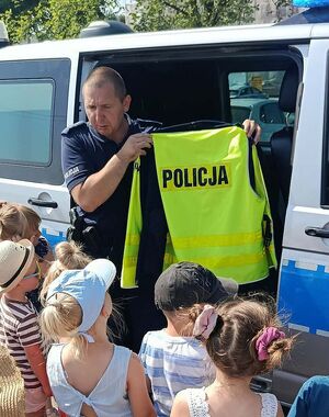 Zdjęcie w kolorze przedstawia policjanta oraz dzieci