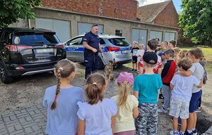 Zdjęcie w kolorze przedstawia policjanta oraz dzieci