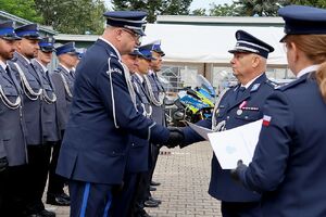 Zdjęcie w kolorze przedstawia pełniącego obowiązki Komendanta Powiatowego Policji w Oleśnie oraz Zastępcę Komendanta Wojewódzkiego Policji w Opolu podczas wręczania   policjantom nominacji na wyższe stopnie.