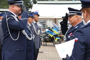 Zdjęcie w kolorze przedstawia pełniącego obowiązki Komendanta Powiatowego Policji w Oleśnie oraz Zastępcę Komendanta Wojewódzkiego Policji w Opolu podczas wręczania   policjantom nominacji na wyższe stopnie.