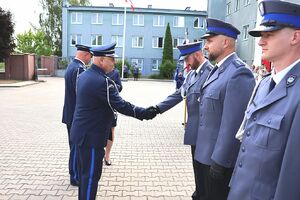 Zdjęcie w kolorze przedstawia pełniącego obowiązki Komendanta Powiatowego Policji w Oleśnie oraz Zastępcę Komendanta Wojewódzkiego Policji w Opolu podczas wręczania   policjantom nominacji na wyższe stopnie.