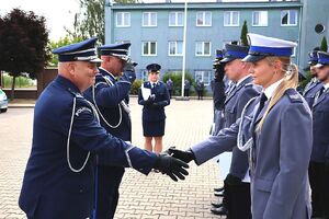Zdjęcie w kolorze przedstawia pełniącego obowiązki Komendanta Powiatowego Policji w Oleśnie oraz Zastępcę Komendanta Wojewódzkiego Policji w Opolu podczas wręczania   policjantom nominacji na wyższe stopnie.