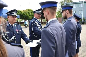 Zdjęcie w kolorze przedstawia pełniącego obowiązki Komendanta Powiatowego Policji w Oleśnie oraz Zastępcę Komendanta Wojewódzkiego Policji w Opolu podczas wręczania   policjantom nominacji na wyższe stopnie.