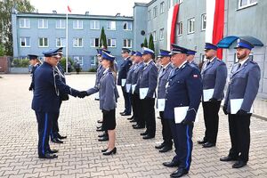 Zdjęcie w kolorze przedstawia pełniącego obowiązki Komendanta Powiatowego Policji w Oleśnie oraz Zastępcę Komendanta Wojewódzkiego Policji w Opolu podczas wręczania   policjantom nominacji na wyższe stopnie.