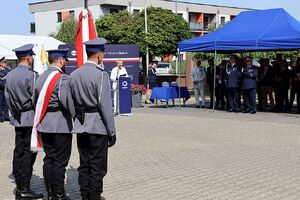Zdjęcie w kolorze przedstawia Policyjny Poczet Sztandarowy oraz gości zgromadzonych podczas obchodów Święta policji w Oleśnie
