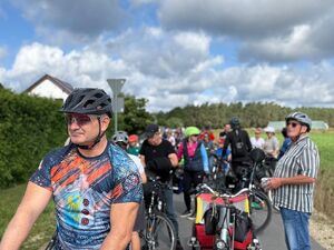 Zdjęcie w kolorze przedstawia na pierwszym planie Komendanta Powiatowego Policji w Oleśnie w stroju sportowym, w tle pozostali uczestnicy rajdu.