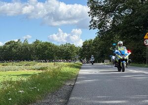 Zdjęcie w kolorze przedstawia policjantów ruchu drogowego którzy jadą na motocyklach,za nimi  uczestnicy rajdu.
