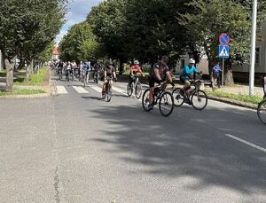 Zdjęcie w kolorze przedstawia uczestników rajdu jadących jezdnią.