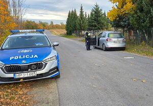 Zdjęcie przedstawia po lewej stronie pojazd oznakowany policji po prawej stronie jedni policjant stoi przy kontrolowanym pojeździe.