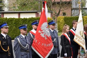 Policjanci stoją ze sztandarem KPP w Oleśnie pośród innych pocztów sztandarowych