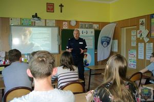 Policjant profilaktyk prowadzi pogadankę z uczniami szkoły w Turzy na temat bezpiecznego korzystania z internetu.