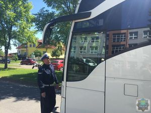 Policjant ruchu drogowego kontroluje światła z przodu autokaru