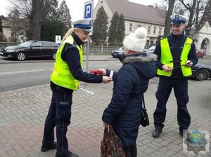 Policjanci ruchu drogowego rozdają opaski odblaskowe podczas akcji &quot;Kobieto świeć przykładem&quot;.