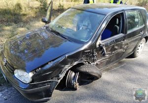 Ciemny volkswagen golf z widocznymi po zderzeniu uszkodzeniami lewego przedniego błotnika, koła i drzwi