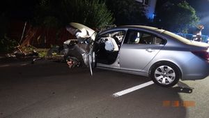 Srebrny opel insignia z uszkodzonym przodem przed nim pozostałości uszkodzonego ogrodzenia.